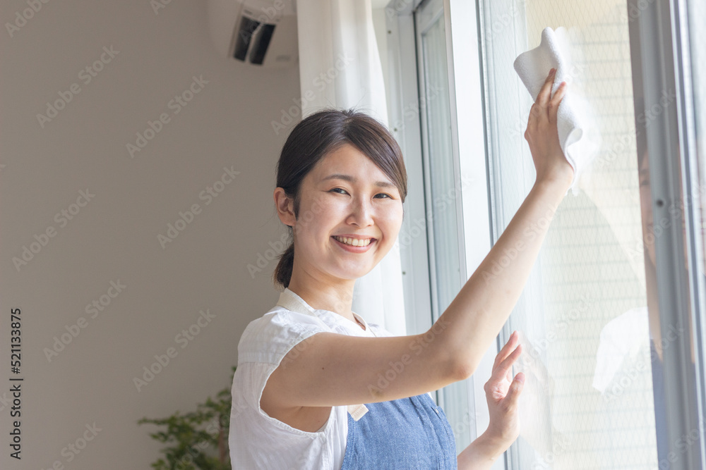 窓拭き掃除をする女性