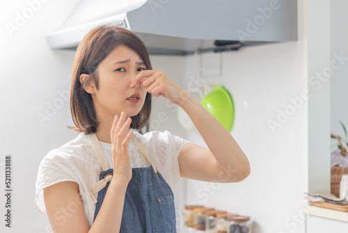 キッチンが臭くて鼻をつまむ女性