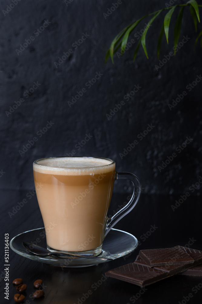 Beans, coffee in glass cup and chocolate on a dark background Beans, coffee in glass cup and chocolate on a dark background
