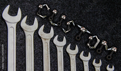 The word Custom made from car parts on the background of a car repair tool