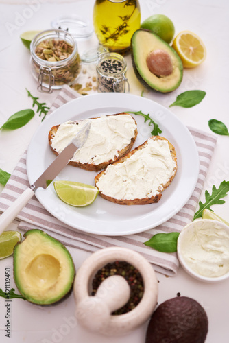 Avocado and cream cheese toasts preparation - grilled or toasted bread with cheese smeared 