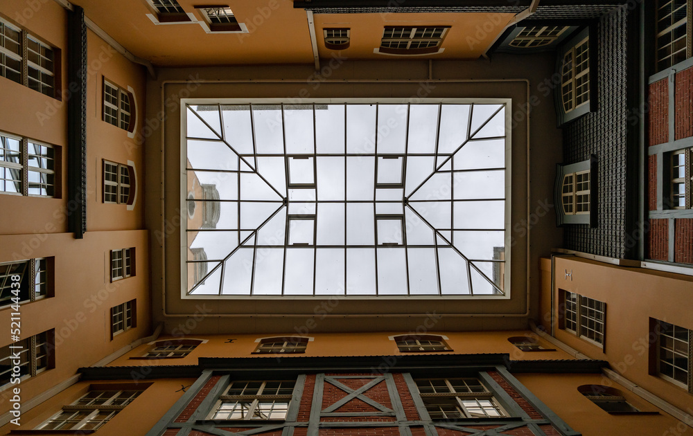 Below view of glass roof from courtyard to old-style brick and orange houses Below view of glass roof from courtyard to old-style brick and orange houses