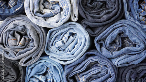 Billede på lærred Stack of Various Shades of Rolled Up Denim Jeans Background Banner Texture