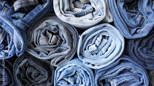 Fotografi Stack of Various Shades of Rolled Up Denim Jeans Background Banner Texture