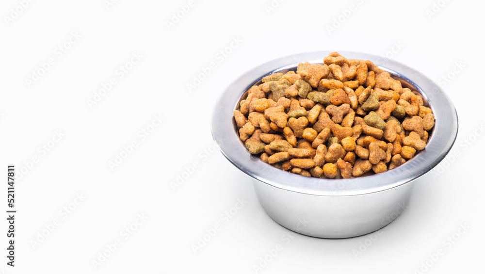 A metal bowl with dry food for animals, cats and dogs, isolated on a white background A metal bowl with dry food for animals, cats and dogs, isolated on a white background