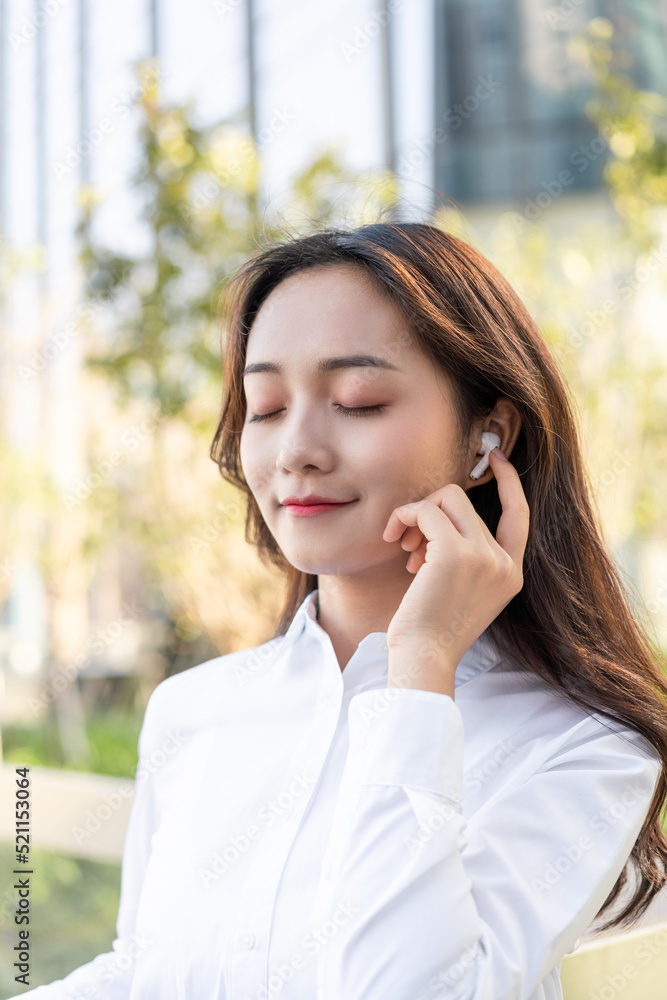 Business women using wireless bluetooth headset outdoors Business women using wireless bluetooth headset outdoors