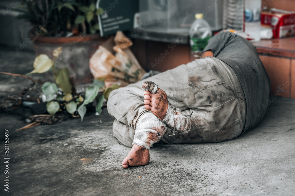 Homeless man sleeps on the street in front of the shop and begging for help and money. Problems of big modern cities Homeless man sleeps on the street in front of the shop and begging for help and money. Problems of big modern cities