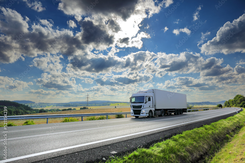 Landscape with a moving truck on the highway at sunset.