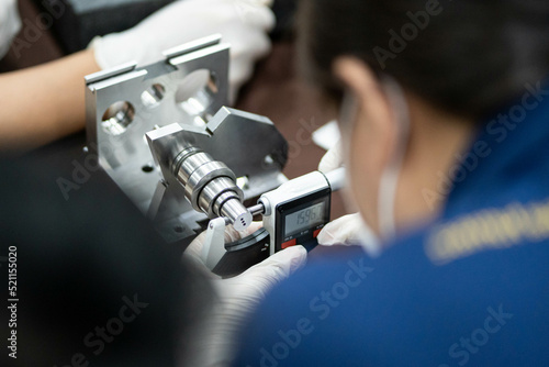 Industrial worker measure detail with digital caliper micrometer at factory workshop