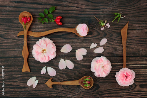 Rose flower natural herbal plant medicine with flowers, petals and rosehips. Nature, alternative floral healing  immune system boosting, high in antioxidants, anthocyanins, vitamin C. On rustic wood.  photo