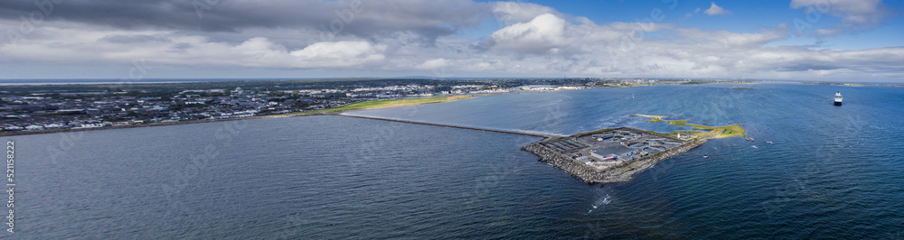 View on Mutton Island and causeway. Galway city, Ireland. Popular town landmark with water treatment plant and old lighthouse and good view on the city. Aerial panorama image.