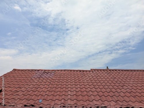 the roof of the house with the warm sun and bright blue sky