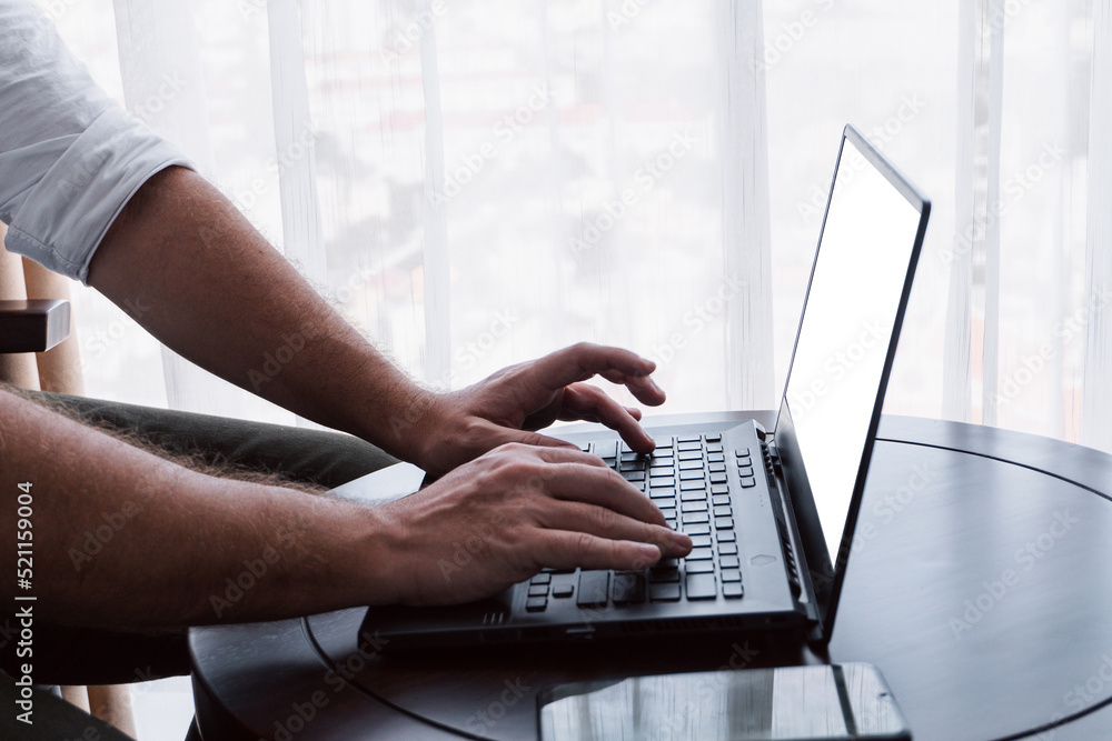Man working on a laptop, hands close-up, remote work, photo on a light background, project management.