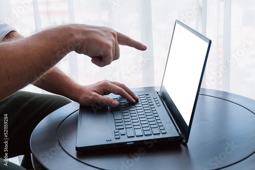 Man working on a laptop, hands close-up, remote work, photo on a light background, project management.