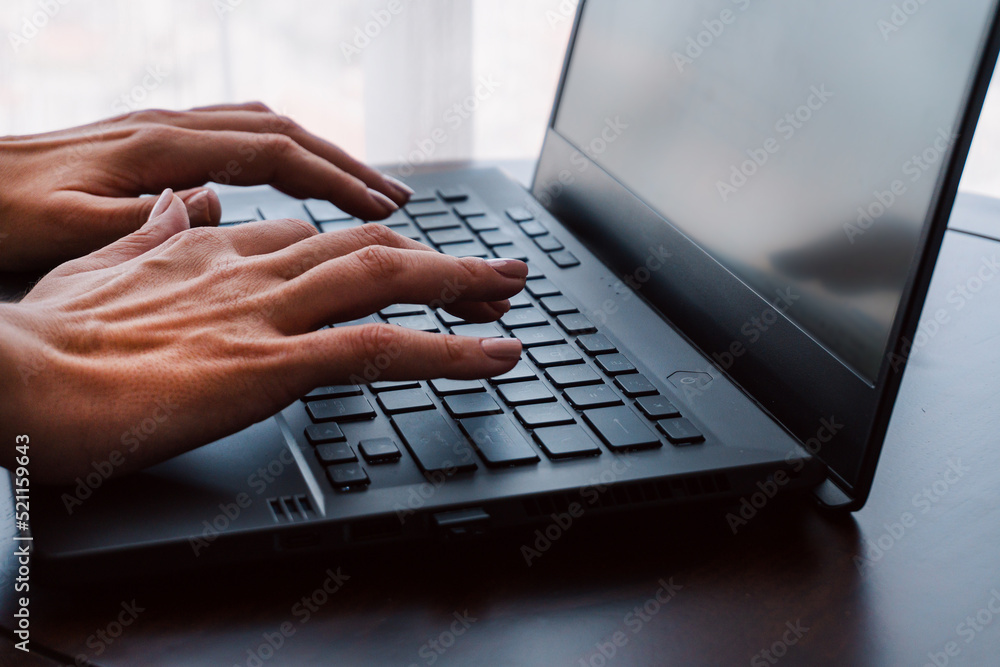 Man working on a laptop, hands close-up, remote work, photo on a light background, project management.