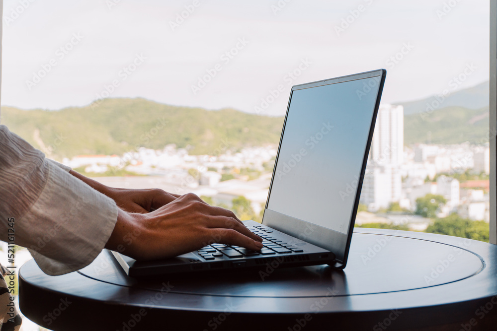 A woman working on a laptop, closeup of her hands and keyboard, the blank screen in the form of a clean template, businesswomen in the office on a light background.