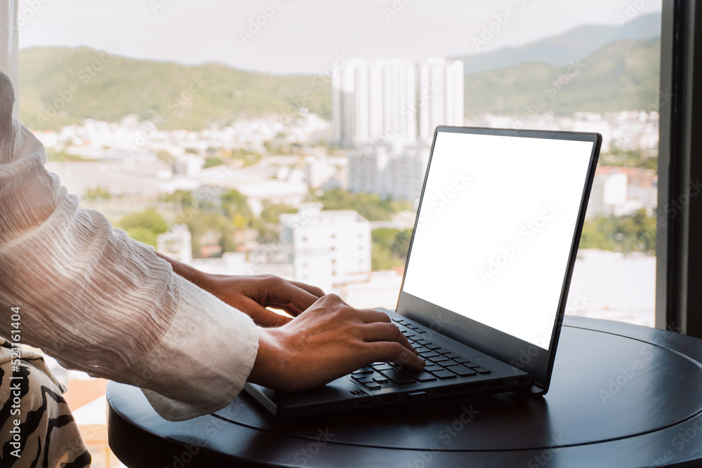 A woman working on a laptop, closeup of her hands and keyboard, the blank screen in the form of a clean template, businesswomen in the office on a light background.