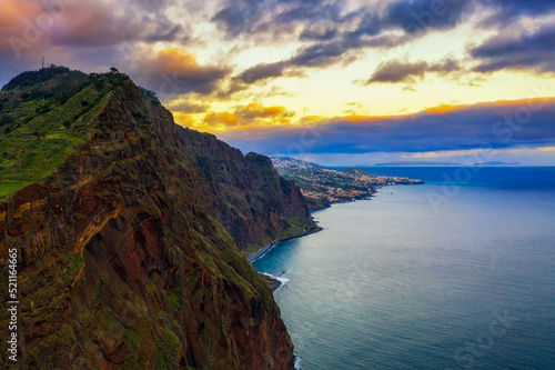Sunset over cliffs of Madeira Island with the city of Funchal in the background