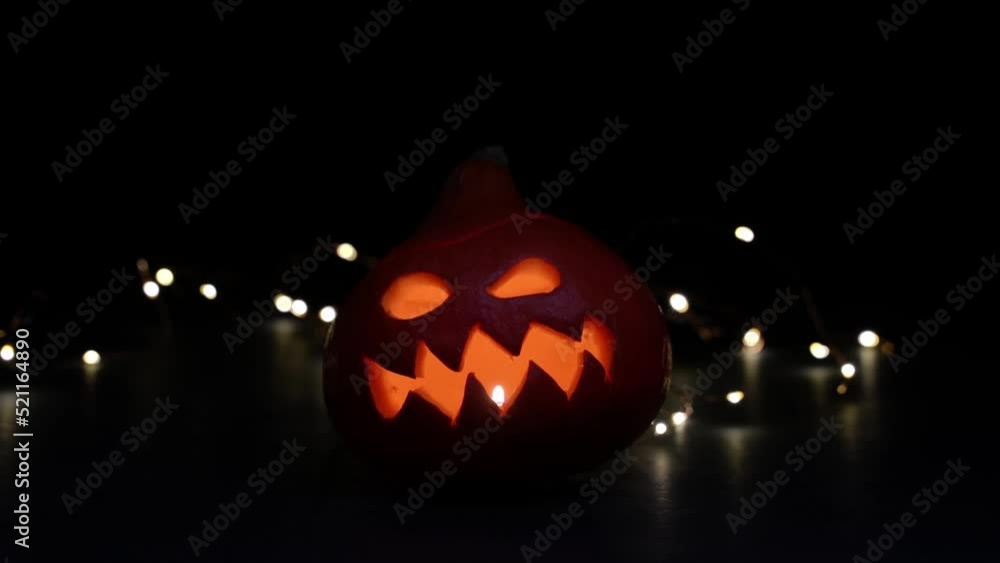 Carved Halloween pumpkin with lights on background. Dark key footage. Carved Halloween pumpkin with lights on background. Dark key footage.