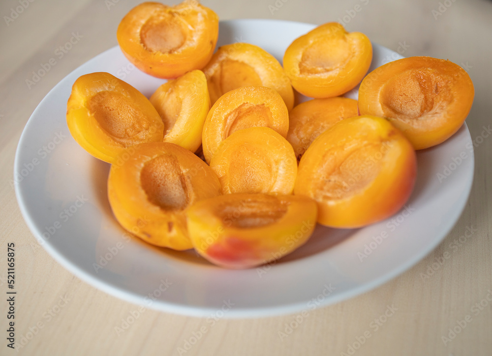 ripe, juicy apricots lie on a white plate. Energy boost, vitamins, ripe fruits, pesticides. Interruptions in the supply of fruits, imports of apricots ripe, juicy apricots lie on a white plate. Energy boost, vitamins, ripe fruits, pesticides. Interruptions in the supply of fruits, imports of apricots