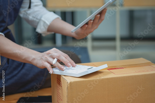 Young businesswoman using a tablet to check online product sales photo