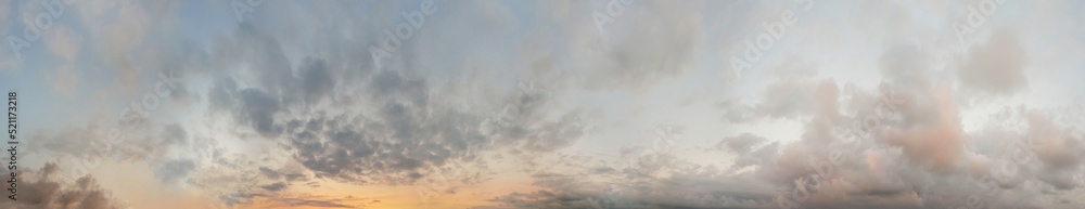 Sunset sky. Panoramic landscape background with yellow sunlight, sky and dramatic fluffy clouds.