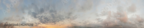 Sunset sky. Panoramic landscape background with yellow sunlight, sky and dramatic fluffy clouds.