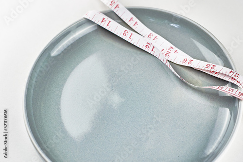 grey plate rewound with measuring tape concept diet