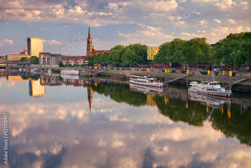 Obraz na płótnie Bremen, Germany. Cityscape image of riverside Bremen, Germany with reflection of the St. Stephani Church in Weser River at summer sunrise. w salonie