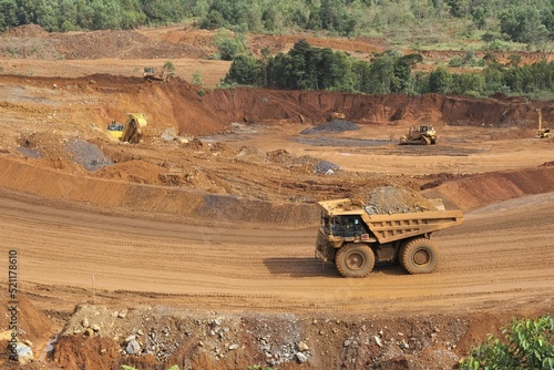 A haul truck is transporting material at a nickel mine site. Rigid dump trucks specifically engineered for use in high-production mining and heavy-duty construction environments.
