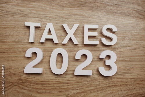 Taxes 2023 alphabet letters on wooden background