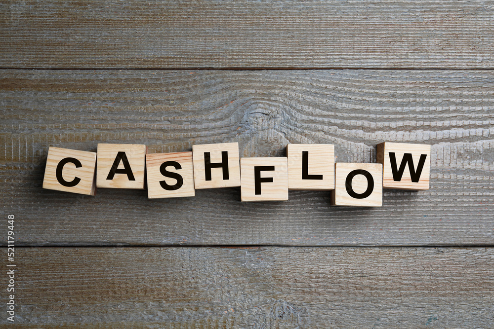 Fototapeta premium Cubes with phrase Cash FLow on wooden background, flat lay