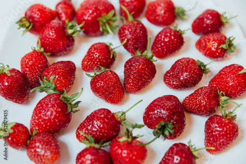 a lot of red strawberries on a white background