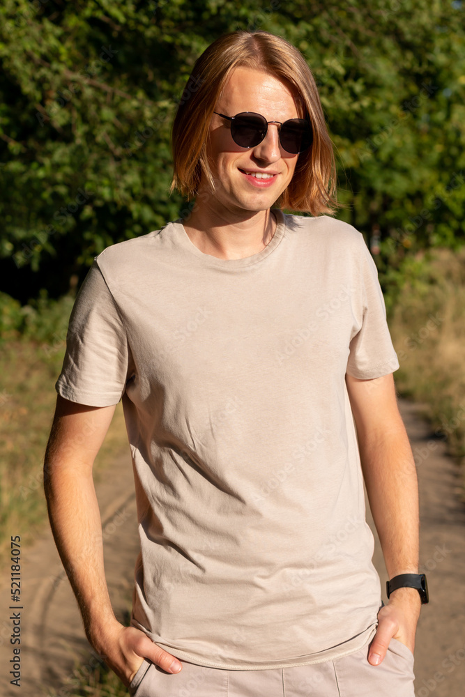 Long hair young man in sunglasses in beige t-shirt Long hair young man in sunglasses in beige t-shirt