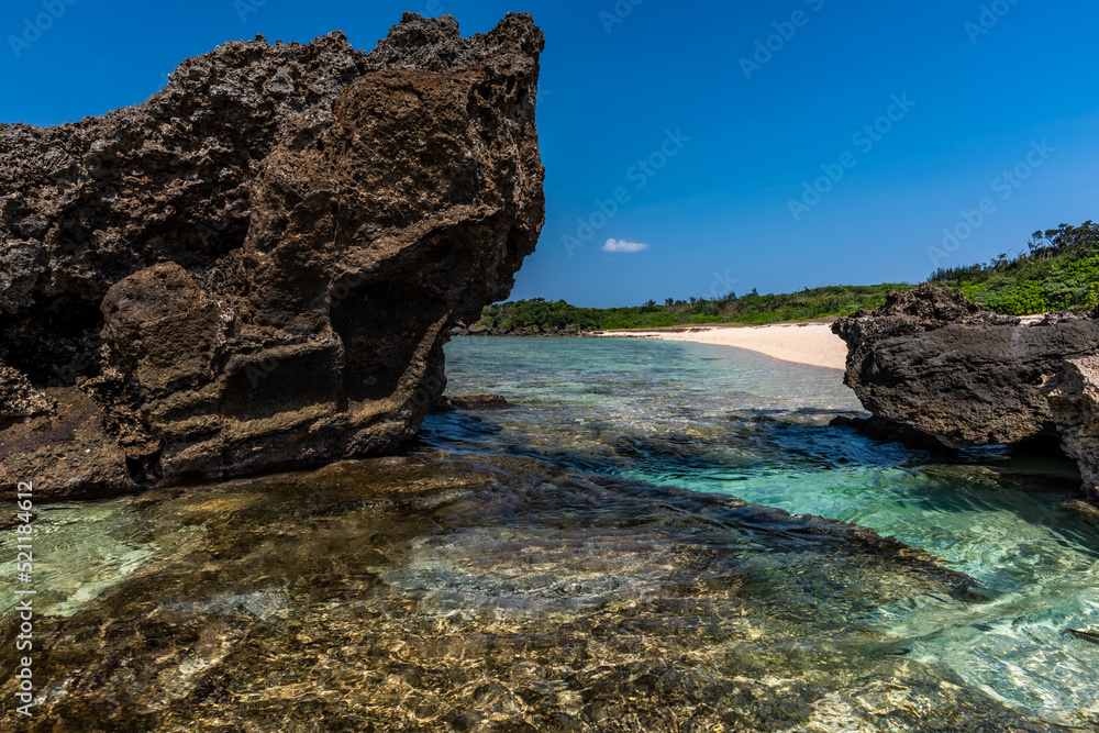 Crystal clear sea water with shiny surface between coastal rocks, sunny day. Okinawa.