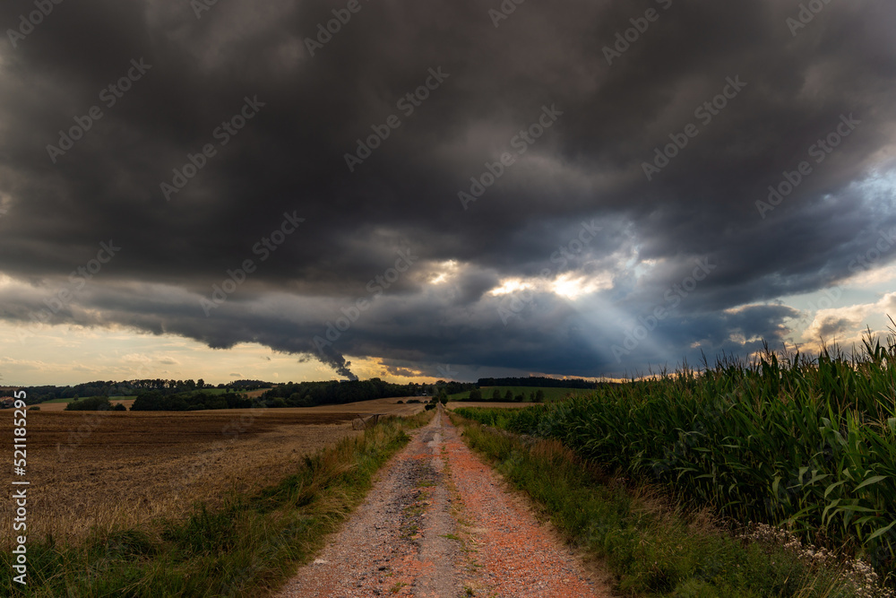 Dramatic storm clouds over fields. Country landscape. Windy weather. Plain field against the background of dark sky.