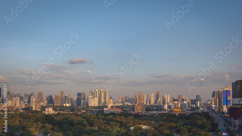 Panorama view of city landscape of modern skyscraper building and office tower in business district during sunset in the evening with clear blue sky. Bangkok metropolitan  capital city of Thailand.