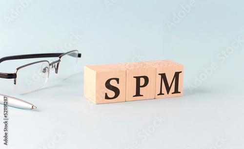 Text SPM - Sales Performance Management - written on the wooden cubes on blue background photo