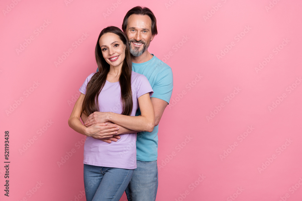 Photo of two lovely peaceful people hug have good mood look camera isolated on pink color background Photo of two lovely peaceful people hug have good mood look camera isolated on pink color background