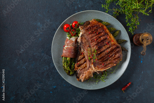 Grilled, medium-baked t-bone beef steak. Served with asparagus.