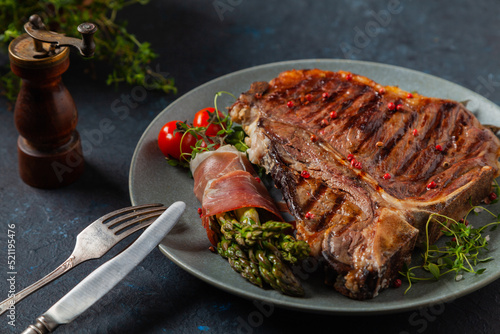 Grilled, medium-baked t-bone beef steak. Served with asparagus. photo