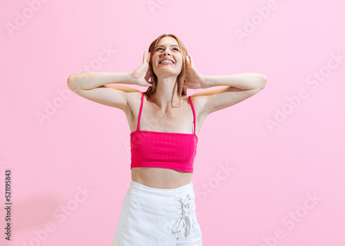 Portrait of young charming girl, student posing isolated on pink background. Concept of beauty, art, fashion, human emotions and facial expressions