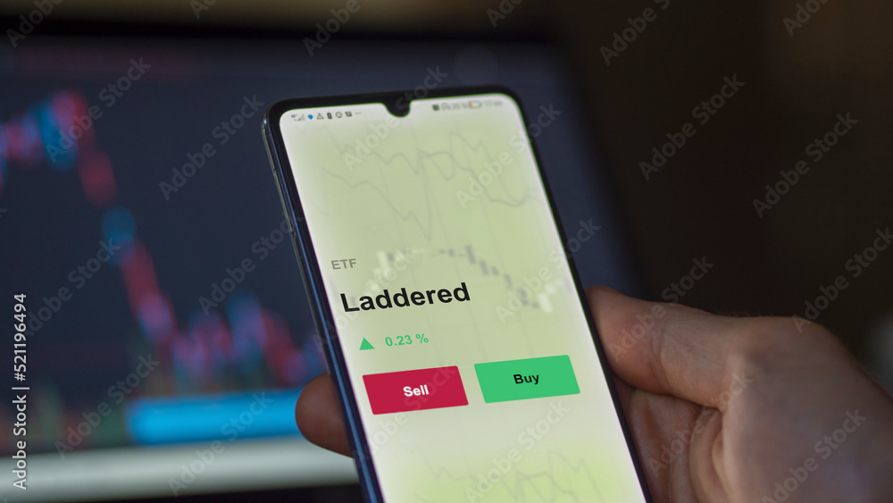 An investor's analyzing the laddered etf fund on a screen to invest. A phone shows the prices of staging and sequencing ETF An investor's analyzing the laddered etf fund on a screen to invest. A phone shows the prices of staging and sequencing ETF