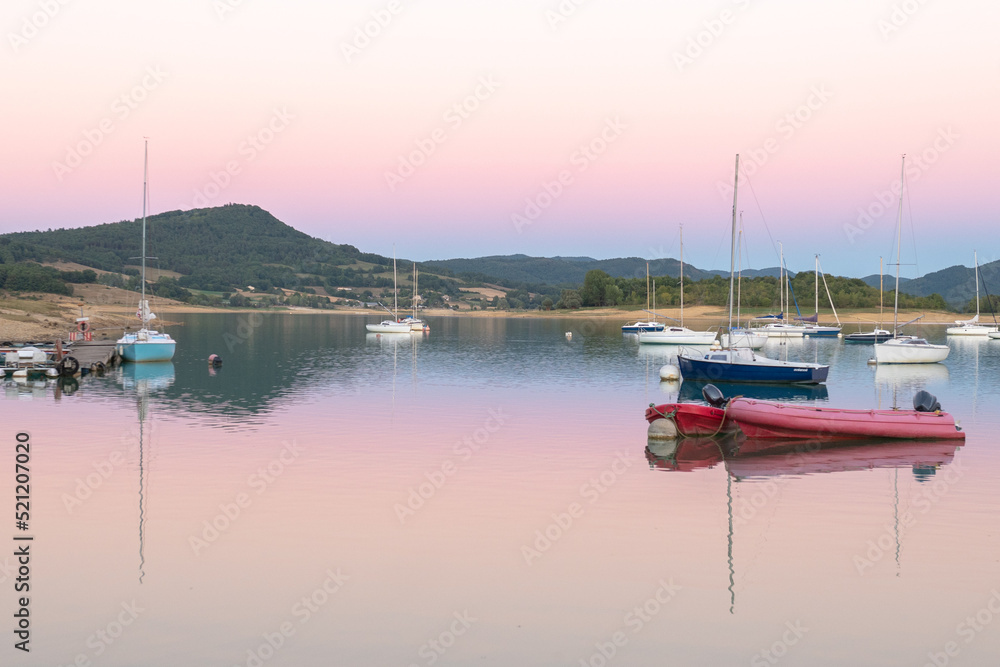 Sunset on Lake Montbel in Ariege with the boats in the summer of 2022.