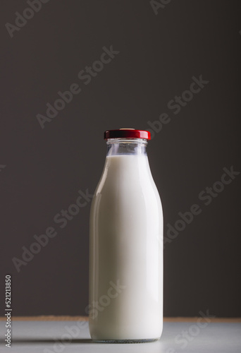 Milk in glass bottle against gray background with copy space