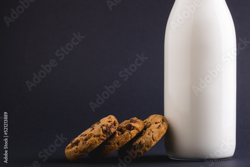 Cookies with milk bottle against gray background, copy space