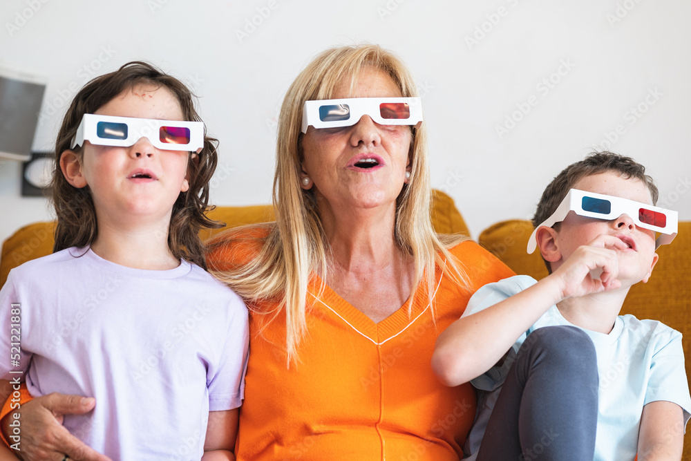 Mother with kids in 3D glasses watching movie at home Mother with kids in 3D glasses watching movie at home