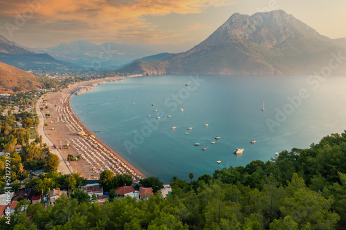 Fototapeta Naklejka Na Ścianę i Meble -  Beautiful sunrise on the sea. Adrasan village on the long beach and Mediterranean coast, sea and mountains in the background, silhouette boats, a great place for vacation. Antalya Turkey