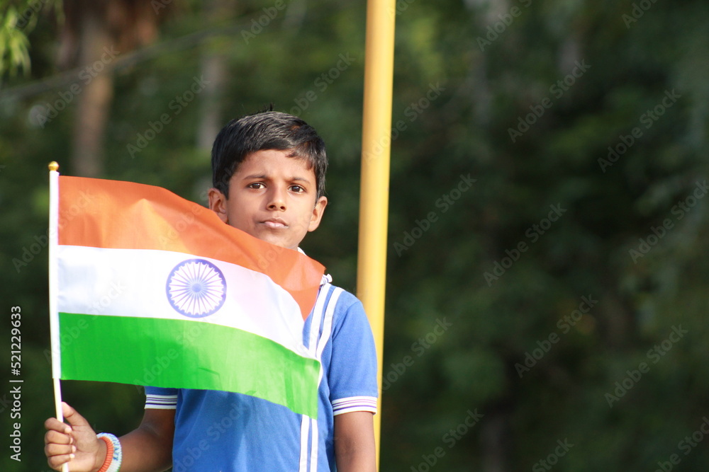 little indian boy proudly holding Indian National flag. The national