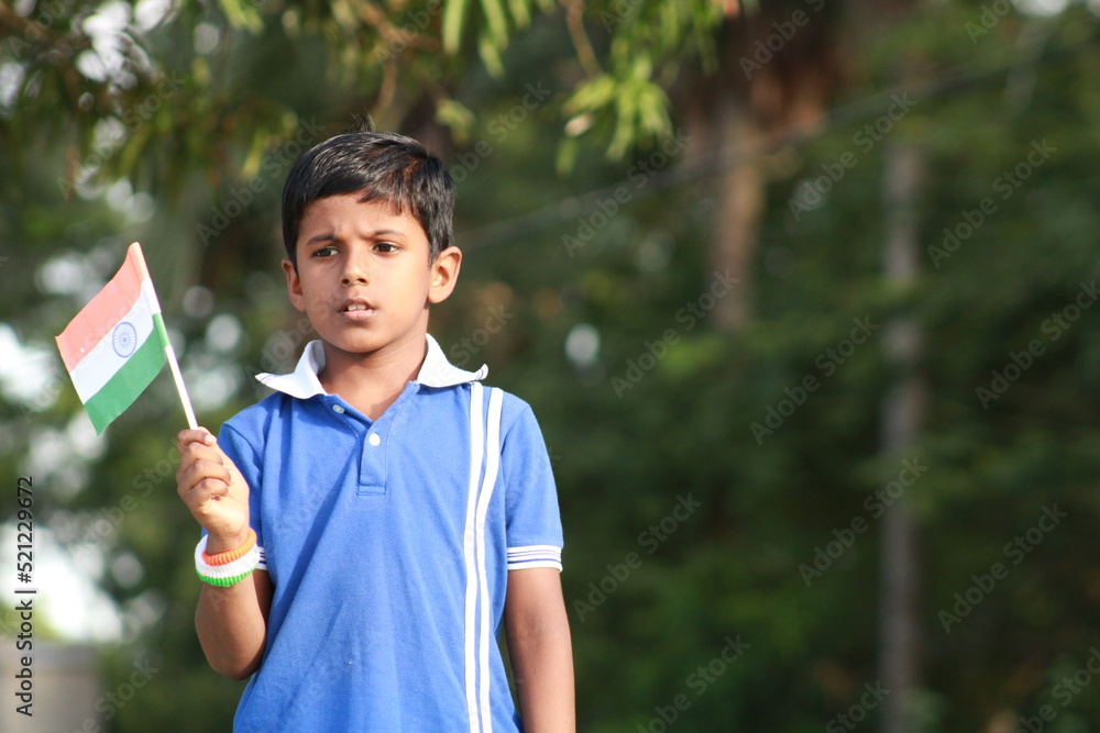 little indian boy proudly holding Indian National flag. The national